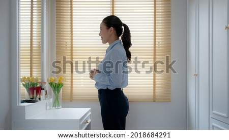 Young female leader, asia people lady or mba student happy standing smile look at in front of mirror pep talk for sale pitch hold paper document script public speak skill for job career self improve. Royalty-Free Stock Photo #2018684291