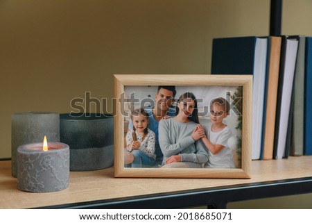 Framed family photo on wooden shelf indoors