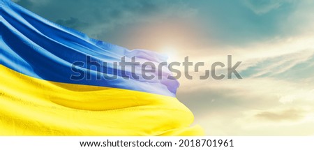 Ukraine national flag waving in beautiful sky.