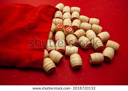 Wooden bingo kegs, on a red background in a red bag, for playing bingo. A way to spend time at home. 2021. High quality photo