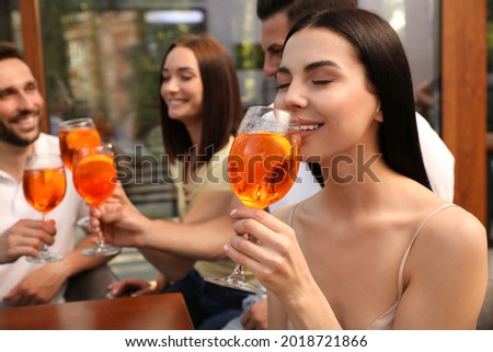 Friends spending time together, focus on young woman drinking Aperol spritz cocktail Royalty-Free Stock Photo #2018721866