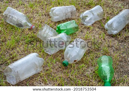 Plastic bottles. A pile of used cut dirty plastic bottles lie on the grass. Environmental pollution concept. Ecological problem. Recycling of plastic waste. Selective soft focus.