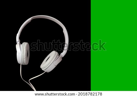 White headphones on a black and green background.