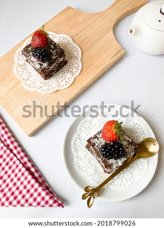 Food photography in a flat lay. A lamington is an Australian cake made from squares of butter cake or sponge cake coated in an outer layer of chocolate sauce and rolled in desiccated coconut
