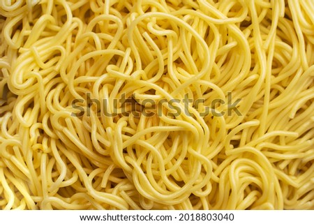 The texture of egg noodles. Yellow noodles are visible throughout the frame. An ingredient for making a wok. Asian food. Asian pasta. Cooking food. Strid food. Gluten-free fries.