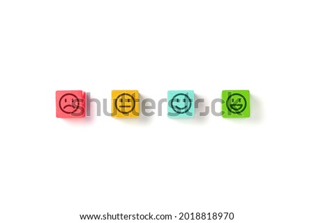 Emoticon faces in colors wooden blocks over white background. Service evaluation and satisfaction survey concepts. Angry, neutral, good mood and happy. Copy space.