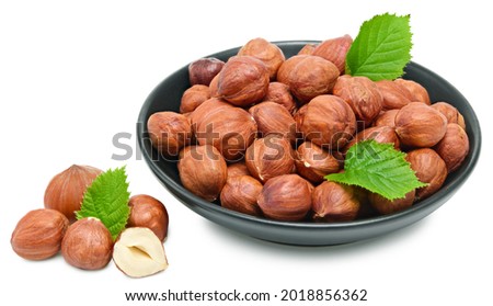 hazelnuts in black bowl isolated on white background macro. clipping path