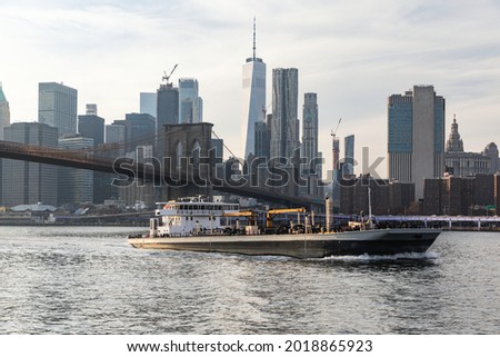 boat on water and a city with tall buildings in the background in summer
