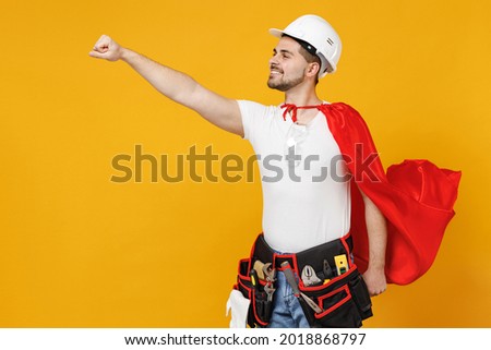 Powerful employee handyman man in superhero suit helmet hardhat makes fly gesture isolated on yellow background studio Real heroes defend you. Instruments renovation apartment room Repair home concept
