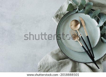 Modern minimal table place setting neutral green color on gray concrete background top view. Space for text .  Modern kitchen.Scandinavian style tableware.Business food brand template. Royalty-Free Stock Photo #2018888501