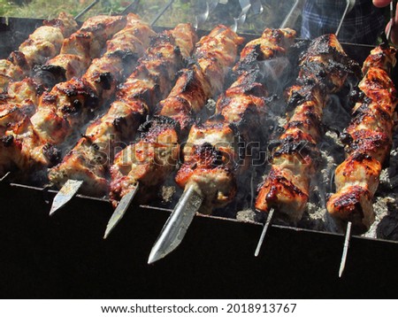 Photo of grilled meat on skewers, close-up. Barbecue cooking for holidays and weekends. Barbecue cooking in the country.                               