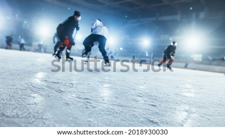 Ice Hockey Rink Arena: In the Background Blurred Professional Players From Different Teams Fighting for the Puck with Stick. Close-up Shot with Focus on Snow. Dutch Angle Shot. Royalty-Free Stock Photo #2018930030
