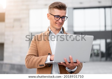 Business. Businessman Using Laptop Outdoor Adult Caucasian Male Business Person Eyeglasses Dressed Hipster Jacket Outside Smiling Happy Positive Emotions Sunlight Background Big City Street