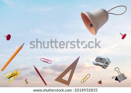Flying school supplies after ring bell in blue sky background with copy space. Back to school concept. Time to go to school Royalty-Free Stock Photo #2018932835