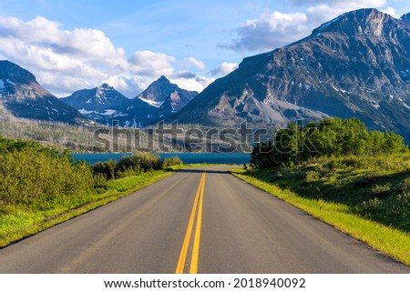 Go To The Sun Road - A Spring evening view of an east section of Go To The Sun Road at Saint Mary Lake, with rugged high peaks towering in the background. Glacier National Park. Montana, USA.  Royalty-Free Stock Photo #2018940092