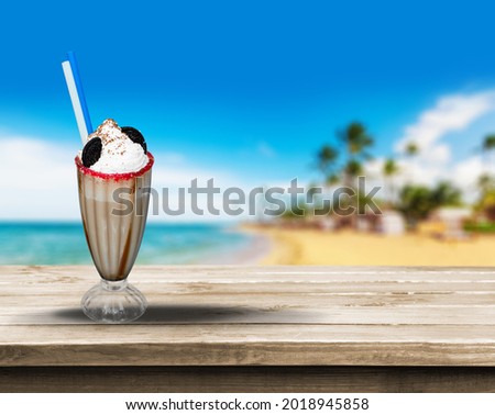 A glass of yummy iced coffee on the seascape background on a summer sunny day