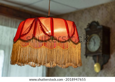 Vintage lampshade made of red fabric with fringes as an element of the decor of the interior of the room Royalty-Free Stock Photo #2018947655