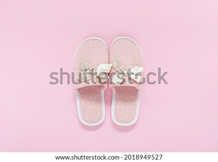 Pink home slippers on a pastel pink background. Top view.