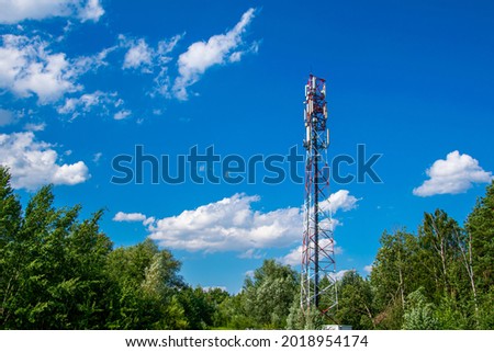 Telecommunication tower of 4G and 5G cellular. Macro Base Station. 5G radio network telecommunication equipment with radio modules and smart antennas mounted on a metal against cloulds sky background. Royalty-Free Stock Photo #2018954174