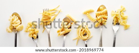Various types of spaghetti, noodles, and pasta on the forks and spoons in the white background Royalty-Free Stock Photo #2018969774