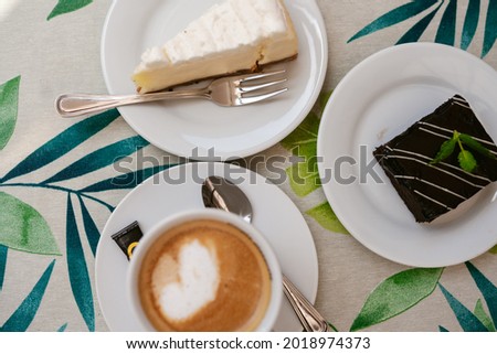 A top view of fresh sweet cakes and a cup of coffee on the table