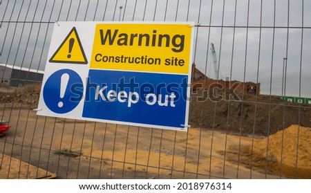 Close up of a Construction site sign on a metal fence
