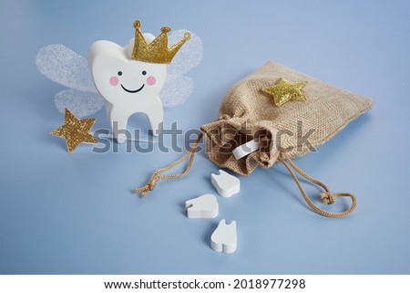 National Tooth Fairy Day. Children tooth fairy. Cute tooth with wings, a crown and a magic wand and bag with teeth. Royalty-Free Stock Photo #2018977298