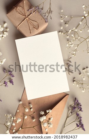 Invitation or greeting card mockup with gift box and dry flowers twigs, stylish top view mockup with copy space