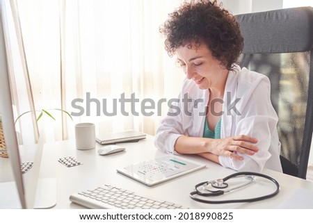 Female doctor consulting the calendar on her tablet