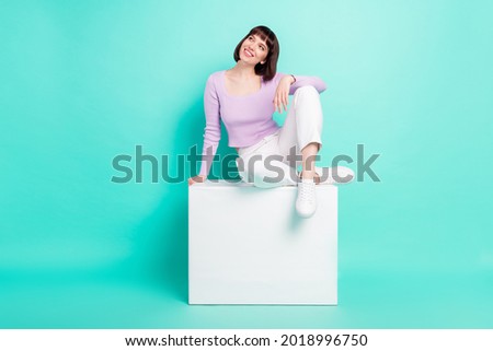Full length body size photo woman sitting wearing stylish clothes looking copyspace isolated bright turquoise color background