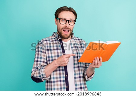 Photo of young man amazed excited point finger book education information isolated over teal color background