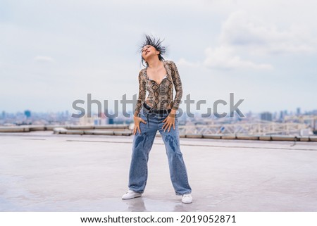 asian female dancer showing contemporary and modern dance performance on rooftop of highrise building in urban