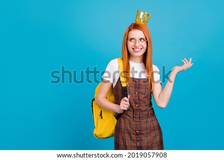 Photo of young school girl happy positive smile queen wear crown hold rucksack isolated over blue color background