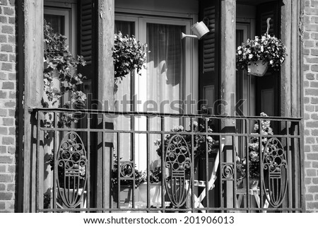 Balcony decorated with flowers in famous resort town Mers-les-Bains. (Picardy, France). Aged photo. Black and white.