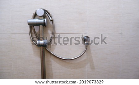 The broken shower hose is wrapped around the hook.