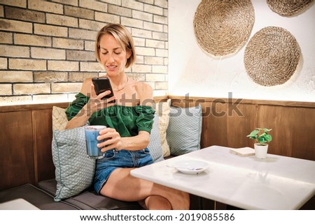 skinny woman using smartphone to take a picture of healthy smoothie