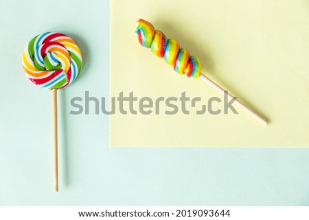 A top view of colorful sweet lollipops isolated on a pastel color background