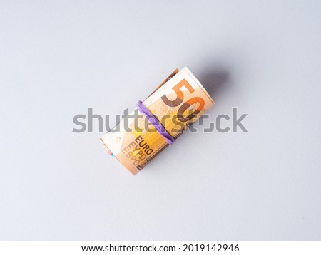 Euro 50 value banknotes roll with rubber on gray background. Financial investment, savings, income earnings concept.