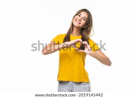 Portrait of a pretty young woman making a heart sign with her hands
