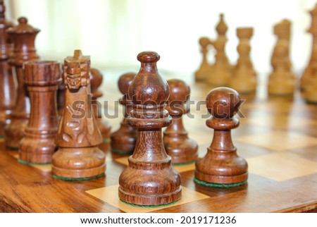 Chess photographed on a chessboard. Wood chess pieces on board game. Brown vintage Chess on blurred background.