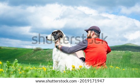 man with dog relaxing in green spring landscape