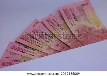 Indonesian Rupiah (IDR) Red 100,000 bank notes currency on white envelope. 