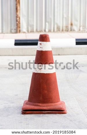 Old traffic cone standing on the road.