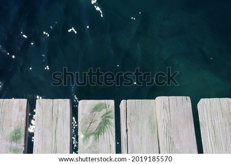 Wooden pier boards on sea water background. Beach vacation