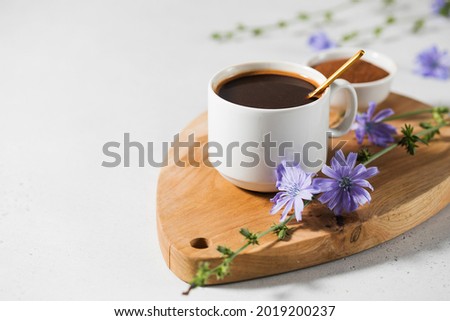 Chicory drink in a white mug with chicory flowers next to it on a wooden board. Royalty-Free Stock Photo #2019200237