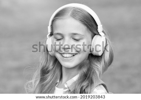 Listen music while walking. Girl headphones listening music. Educational podcast. Kid girl enjoy music. Pleasant time. Child headphones listen music. Audio book concept. Studying audio lessons