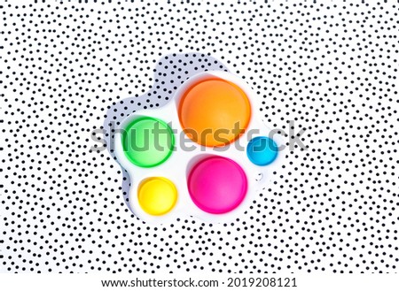 Anti-stress sensory fidget toy simple dimple on a stylish background in a dot . Macro image. Shadow.  Royalty-Free Stock Photo #2019208121