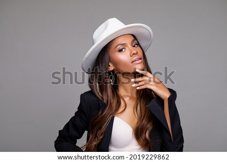 Fashion Portrait of stylish black woman in a Hat. Makeup - beige Lips. Beautiful model African American girl posing in a white stylish hat in the studio    Royalty-Free Stock Photo #2019229862
