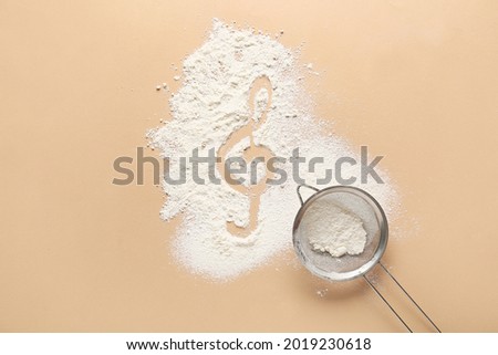 Violin clef drawn on flour against color background