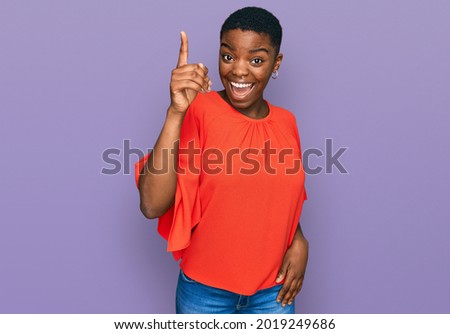 Young african american woman wearing casual clothes pointing finger up with successful idea. exited and happy. number one.  Royalty-Free Stock Photo #2019249686
